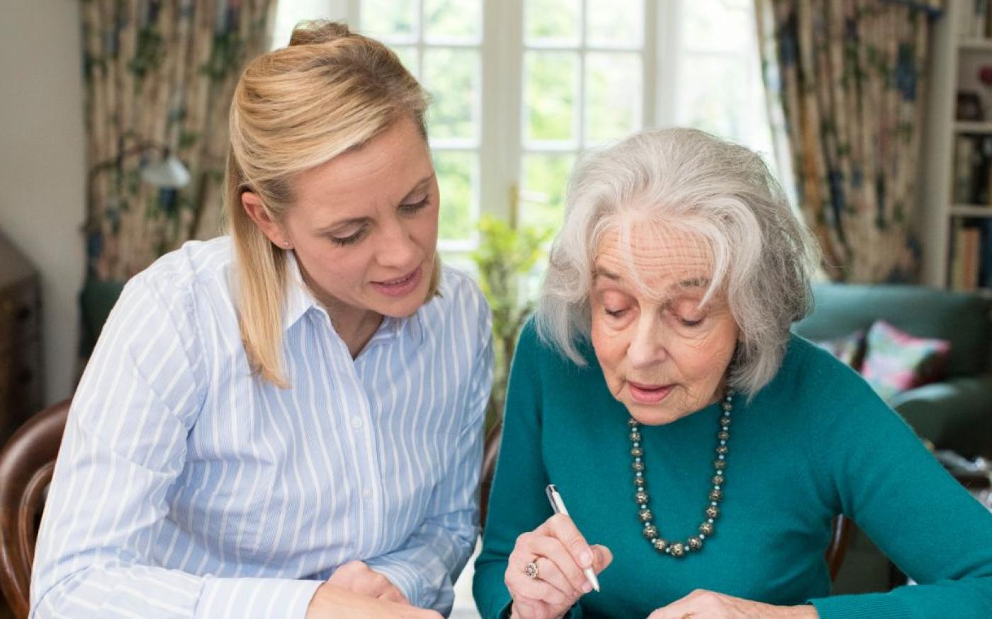 Woman helping elderly woman with finance